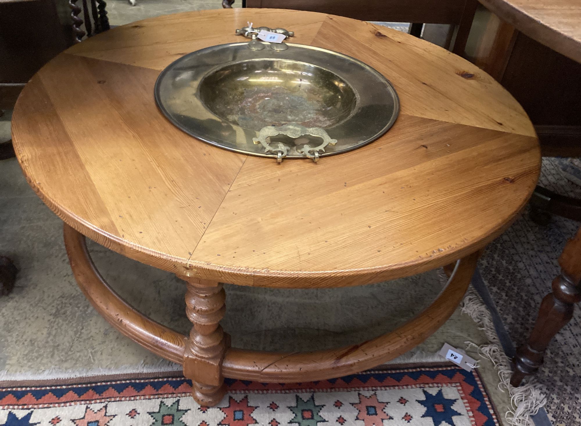 A circular pine low table inset two-handled brass brazier, diameter 108cm height 43cm